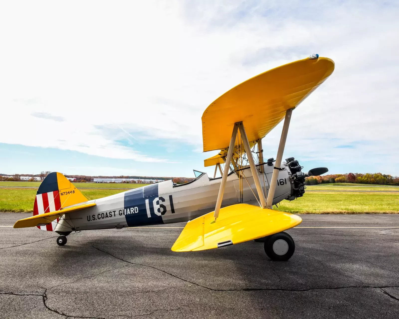 Boeing PT-17 Stearman N73449, a silver and yellow biplane in U.S. Coast Guard livery